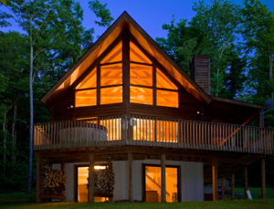 Well-lit cabin in forest in evening