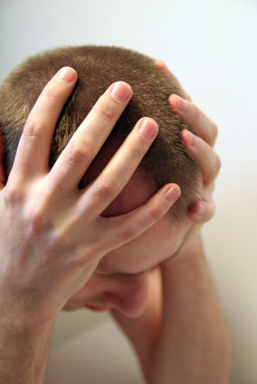 Photo of stressed man holding his head.
